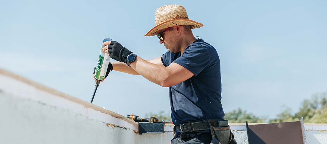 Contractor applying epoxy to a roof.