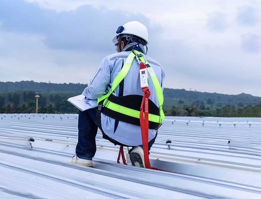 Contractor on low slope metal roof